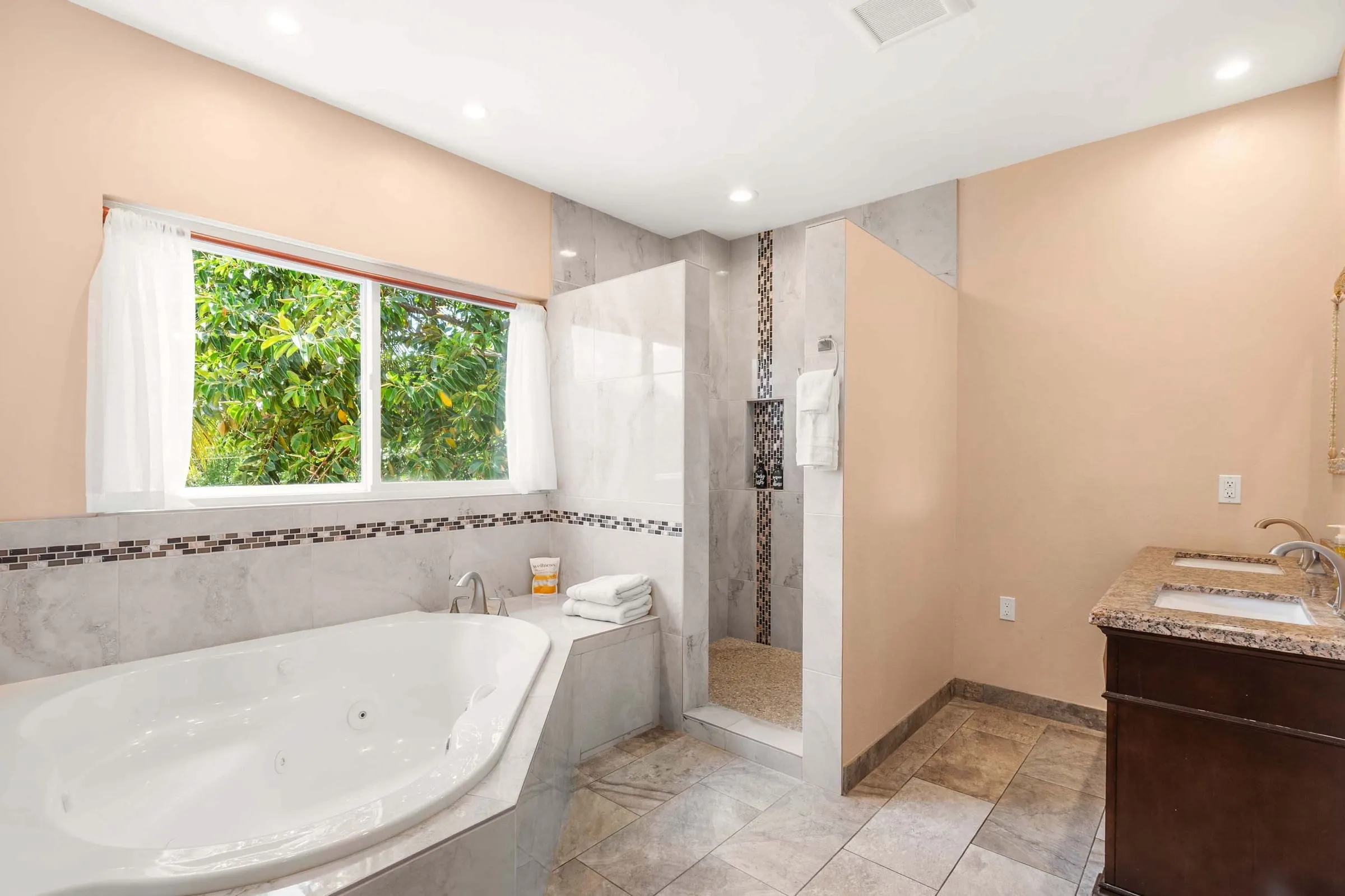 Baño con tina de hidromasaje esquinera y ducha