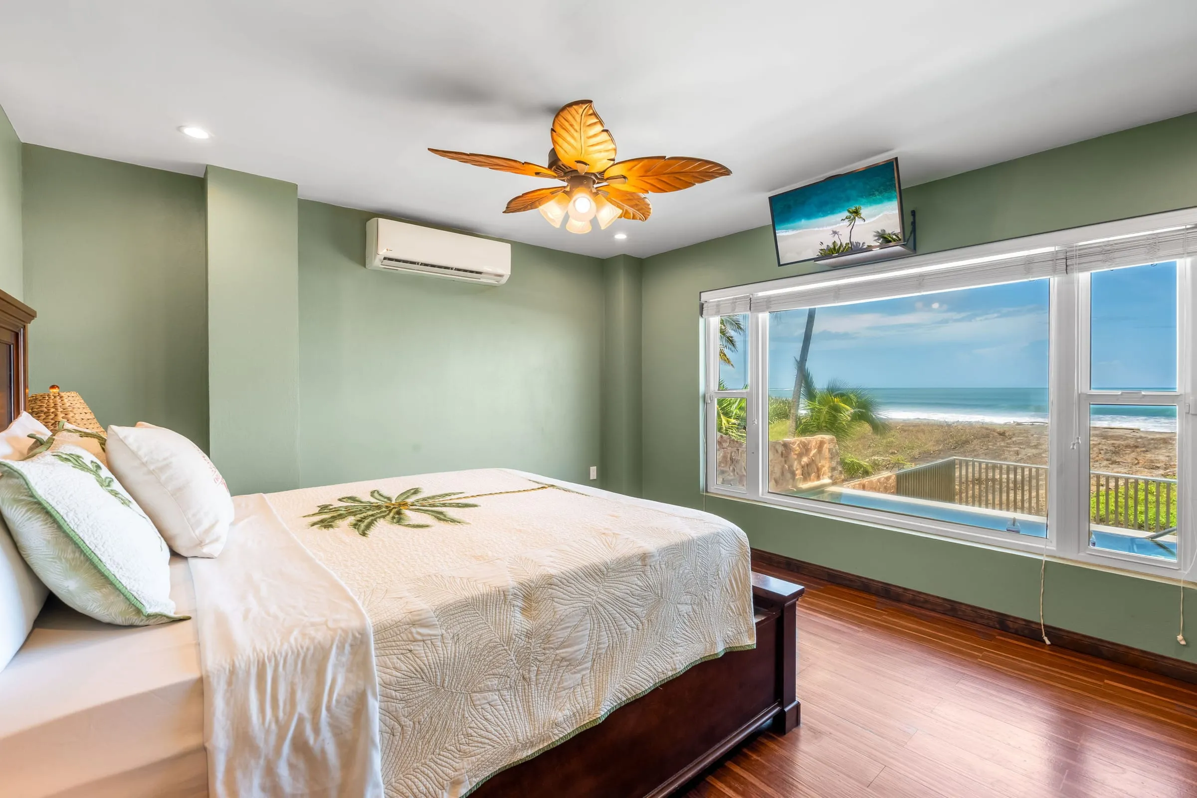 Habitación con cama king y una ventana grande frente a la playa