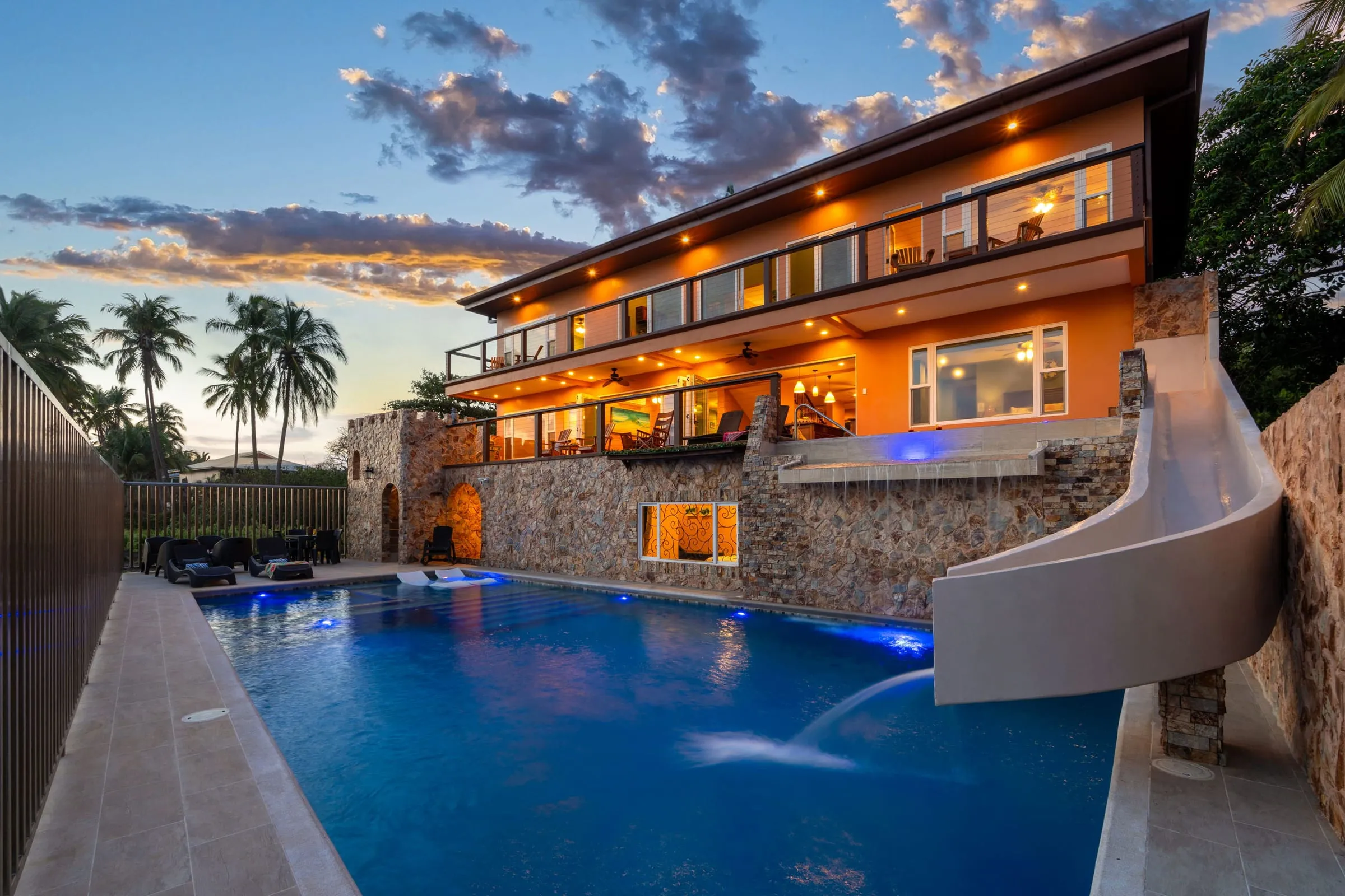 La casa, la piscina y el tobogán al anochecer