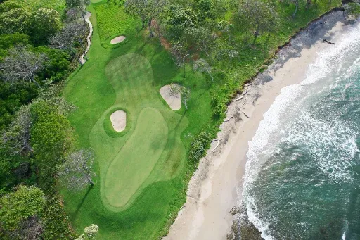 Vista aérea de un green de golf junto a la playa