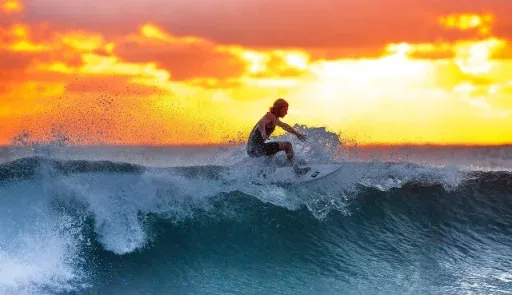 Un surfista en una ola al atardecer