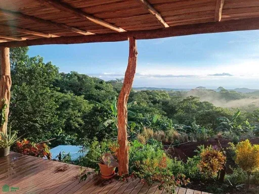 Terraza al aire libre bajo techo con vista a colinas boscosas